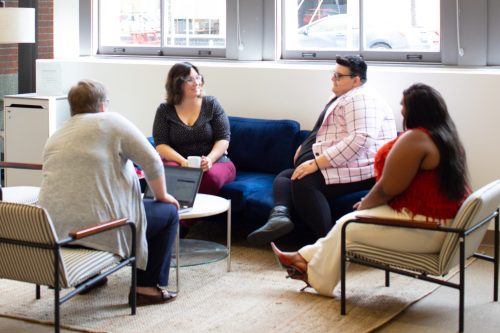 four seated adults having a discussion