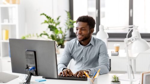 man sitting at desk working at the computer